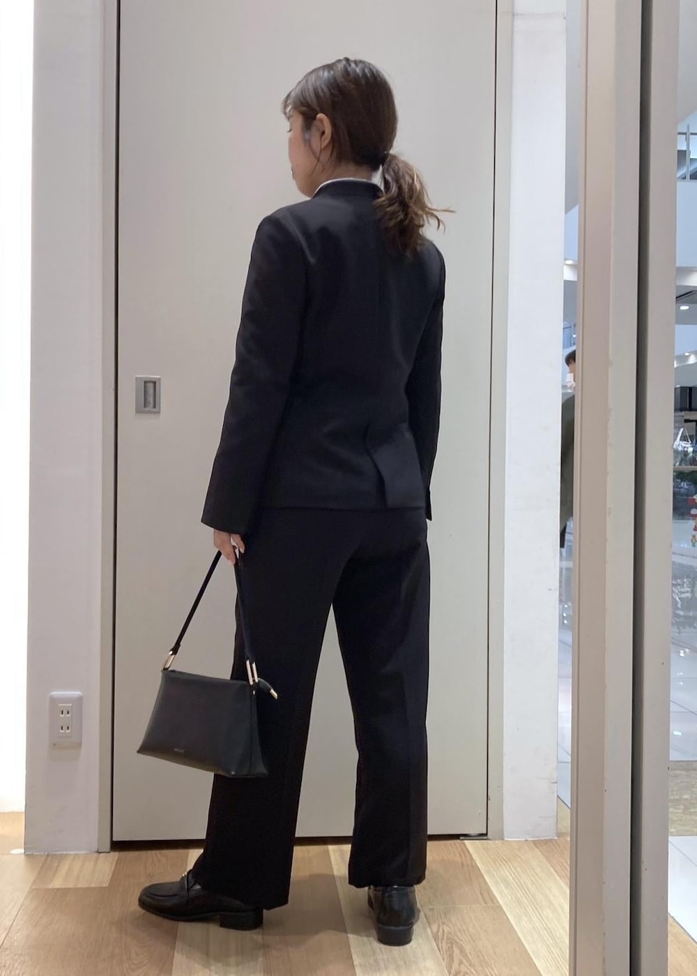 ブルー系のシャツ/ブラウス、ブラック系のショルダーバッグ、ブラック系のローファーを着用したレディースの冬コーディネートの2枚目の写真