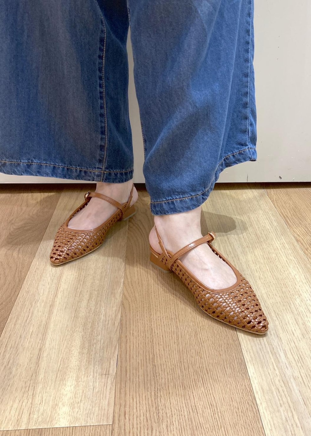 ブラウン系のパンプス、イエロー系のトートバッグ、ブルー系のデニムパンツを着用したレディースの夏コーディネートの7枚目の写真