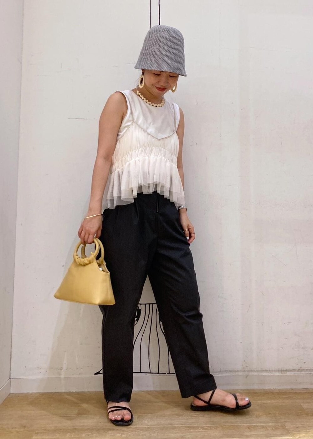 ブラック系のサンダル、ホワイト系のTシャツ/カットソー、イエロー系のショルダーバッグを着用したレディースの夏コーディネートの3枚目の写真