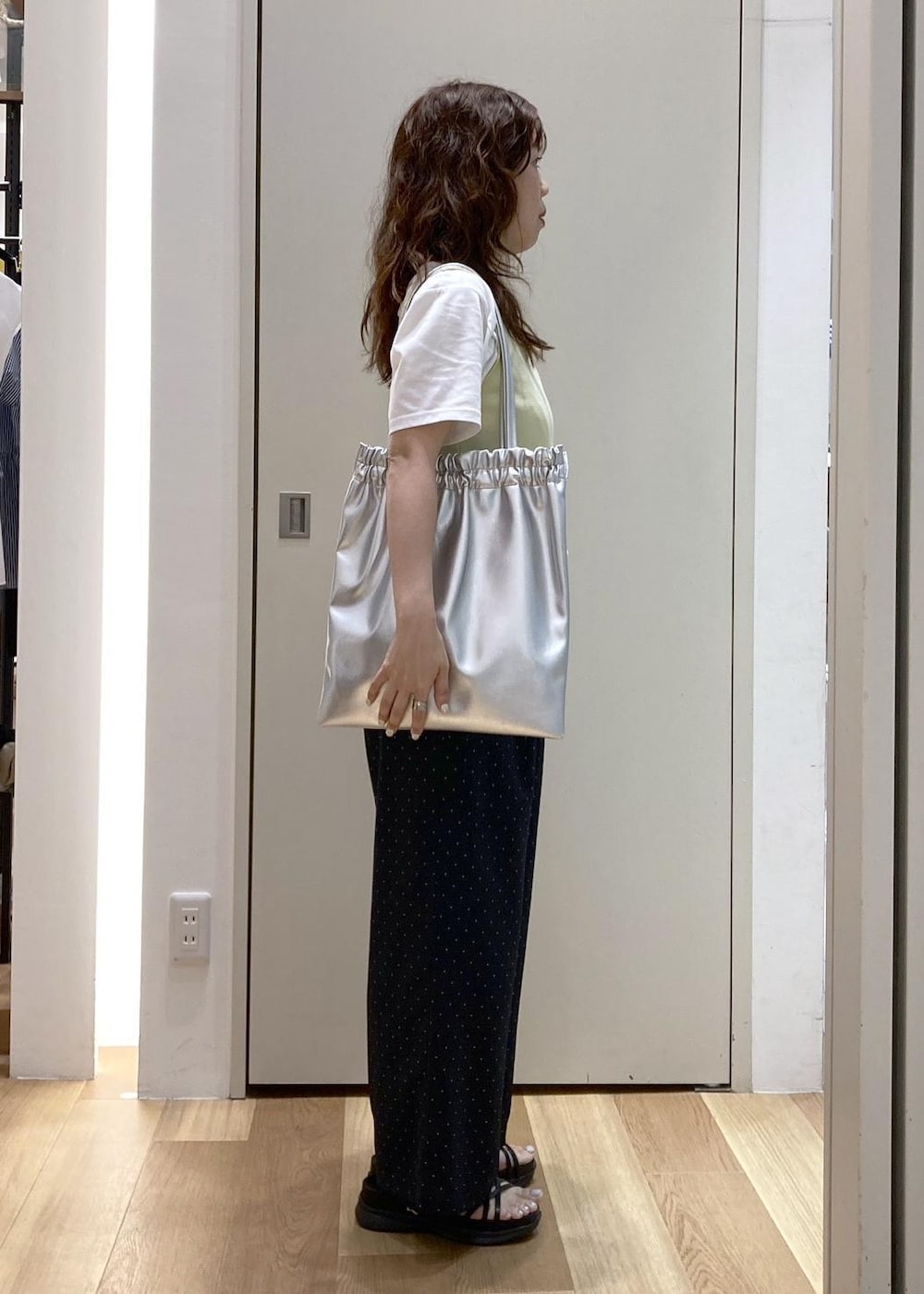 ベージュ系のタンクトップ、ホワイト系のTシャツ/カットソー、ブラック系のサンダルを着用したレディースの夏コーディネートの2枚目の写真