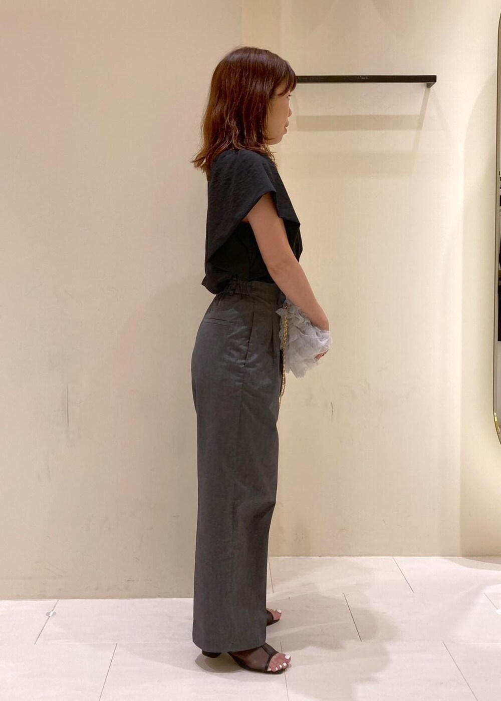 グレー系のショルダーバッグ、ブラック系のパンプス、ブラック系のシャツ/ブラウスを着用したレディースの夏コーディネートの2枚目の写真