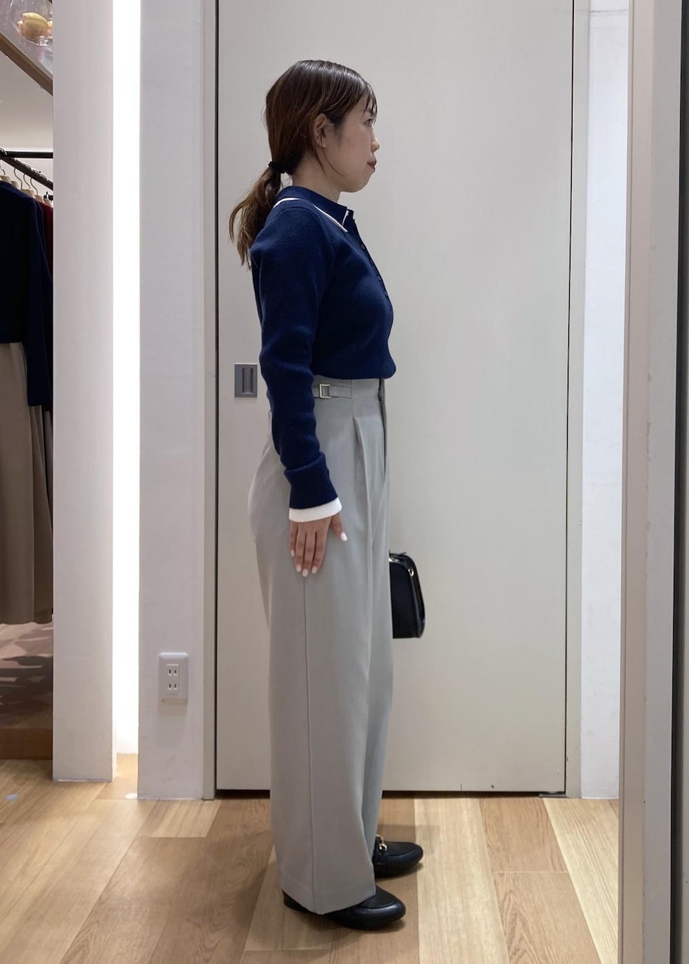 ブラック系のローファー、ブラック系のボストンバッグ、グリーン系のその他パンツを着用したレディースの冬コーディネートの2枚目の写真