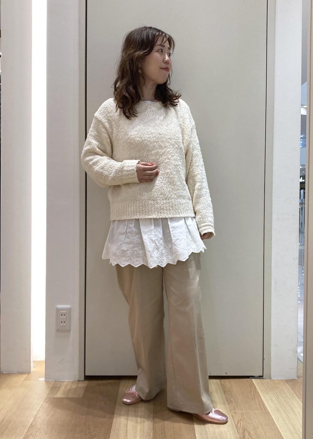 ベージュ系のチノパンツ、イエロー系のトートバッグ、ホワイト系のニット/セーターを着用したレディースの春コーディネートの5枚目の写真