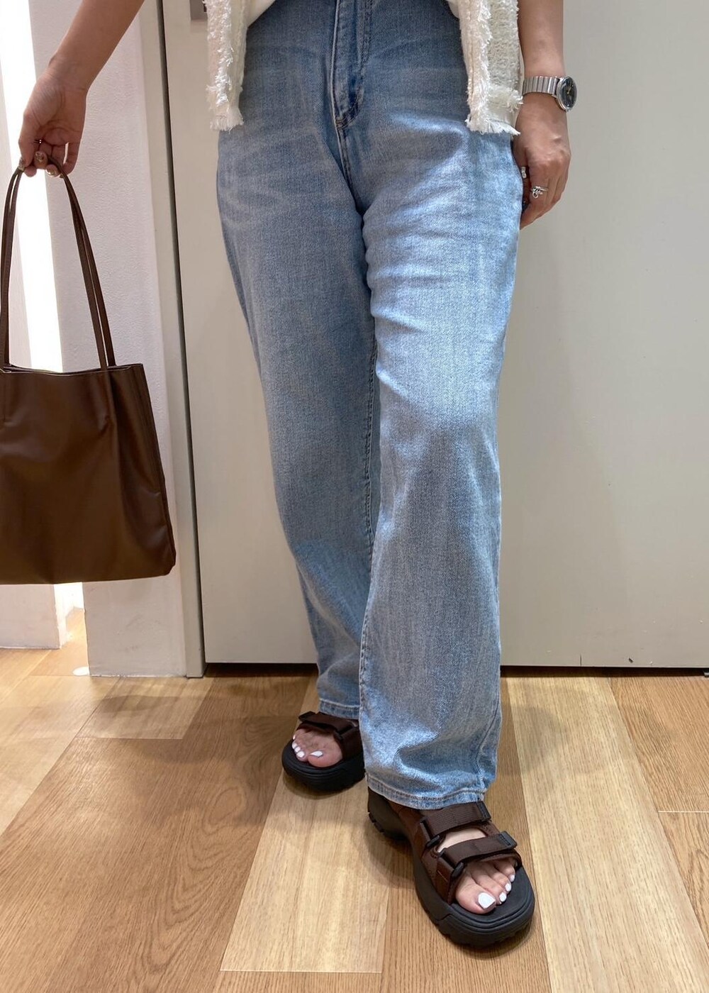 ホワイト系のカーディガン/ボレロ、ブラウン系のサンダル、ホワイト系のTシャツ/カットソーを着用したレディースの夏コーディネートの5枚目の写真