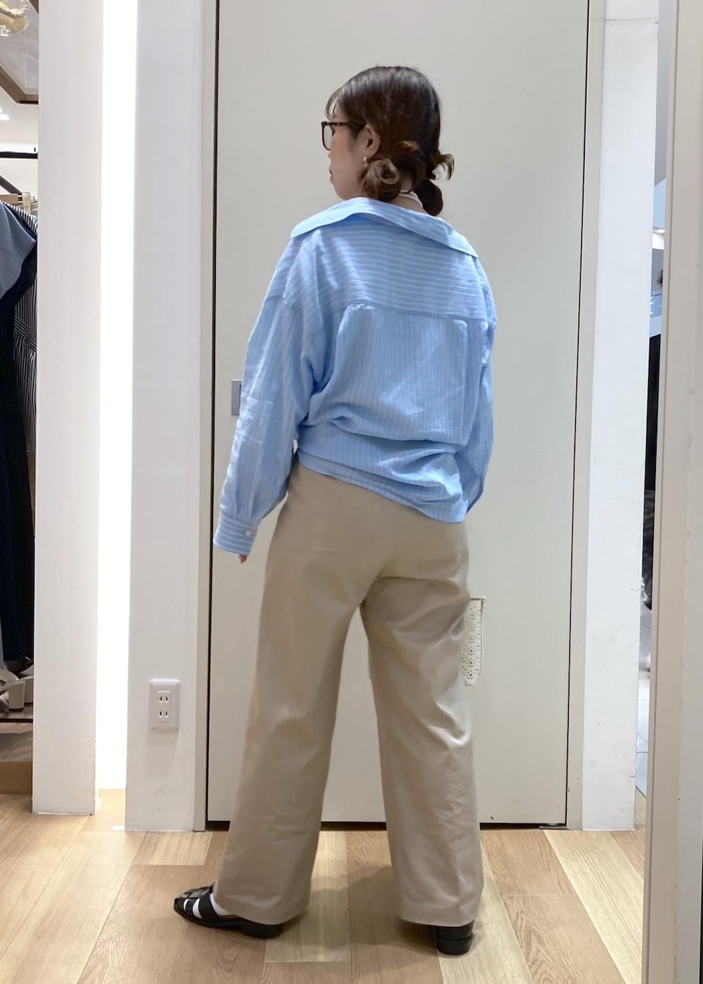 ベージュ系のチノパンツ、ブラック系のサンダル、ホワイト系のショルダーバッグを着用したレディースの春コーディネートの3枚目の写真