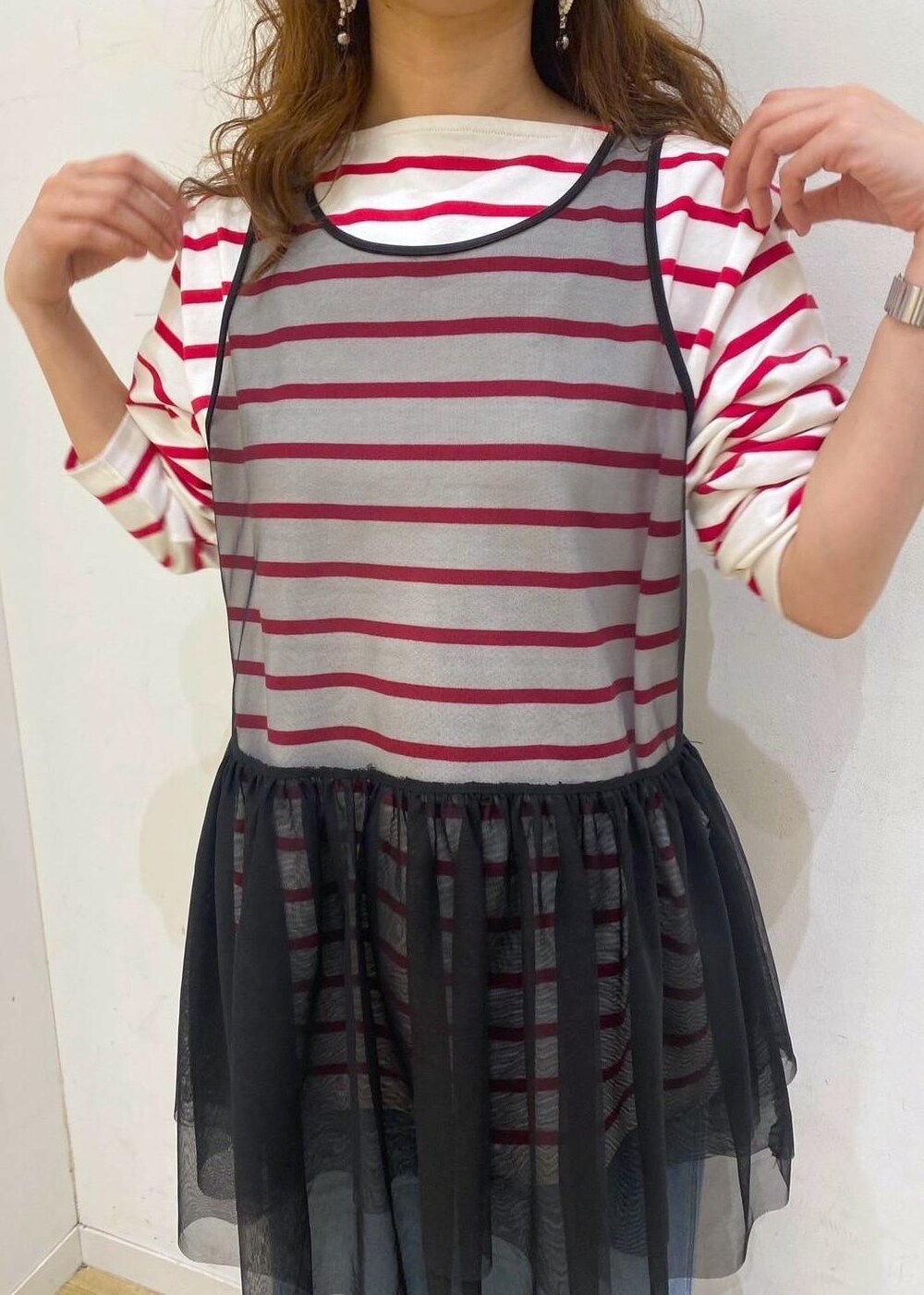 ブラック系のベスト、レッド系のTシャツ/カットソー、ホワイト系のパンプスを着用したレディースの春コーディネートの4枚目の写真