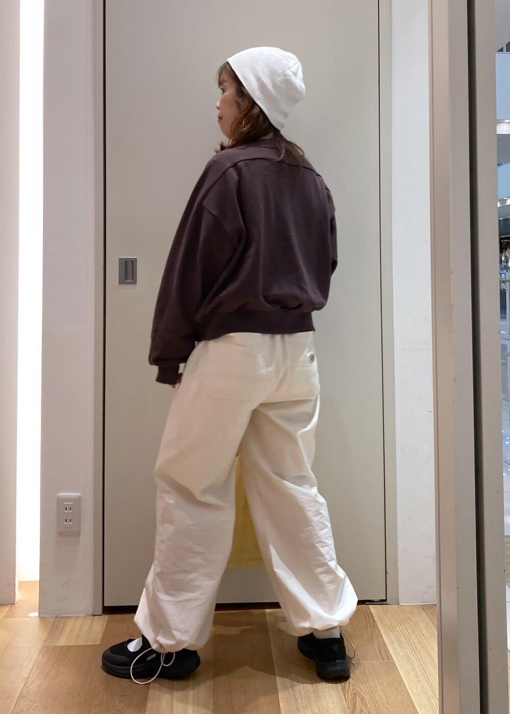 ブラック系のスニーカー、ホワイト系のその他パンツ、ブラウン系のカーディガン/ボレロを着用したレディースの秋コーディネートの3枚目の写真