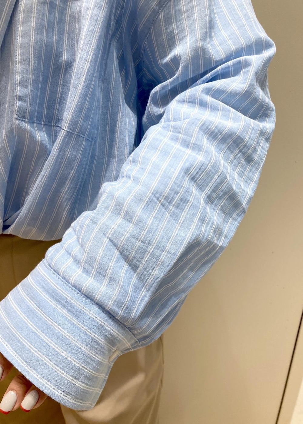 ベージュ系のチノパンツ、ブラック系のサンダル、ホワイト系のショルダーバッグを着用したレディースの春コーディネートの5枚目の写真