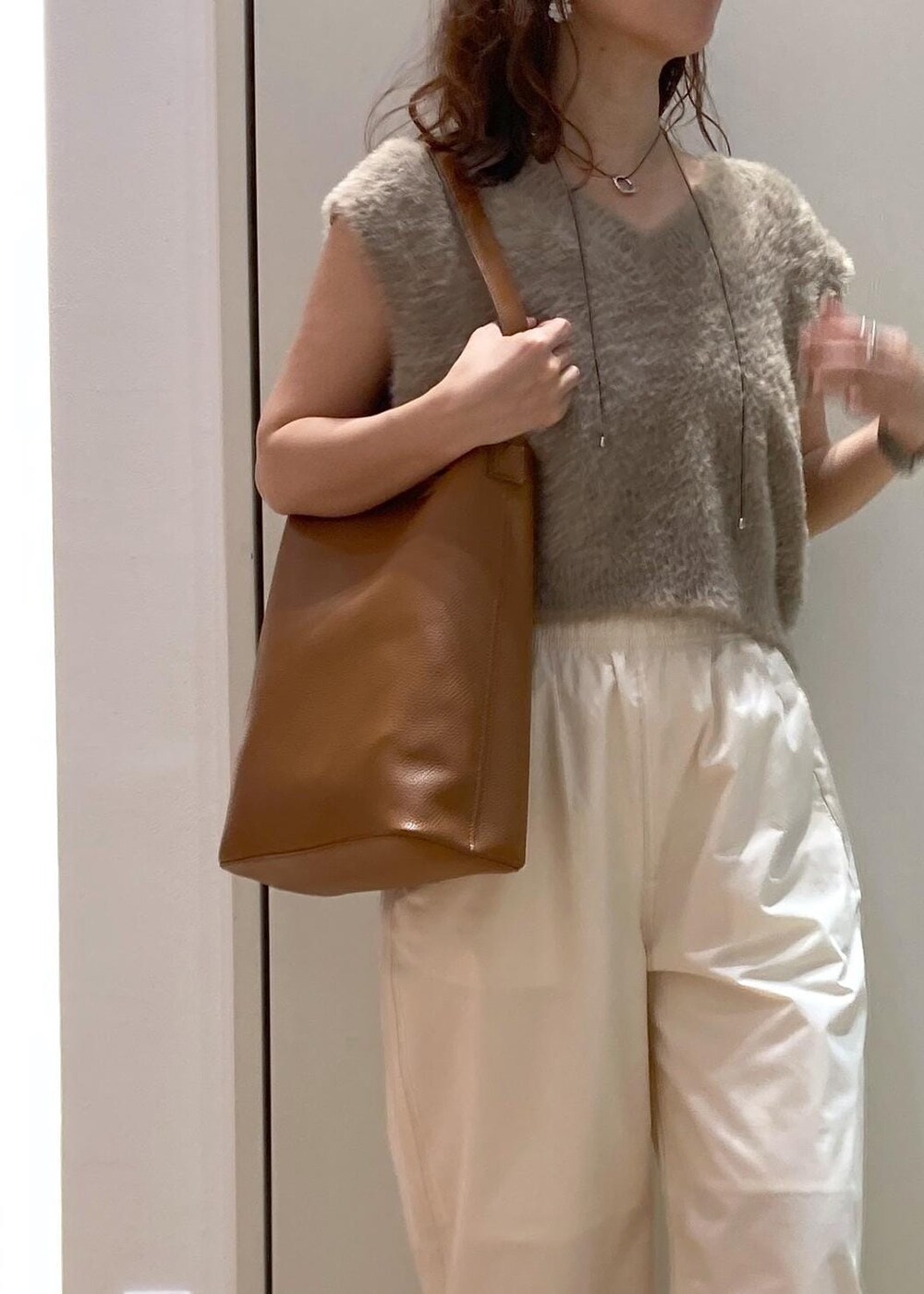 ベージュ系のローファー、ブラウン系のショルダーバッグ、ベージュ系のベストを着用したレディースの夏コーディネートの7枚目の写真