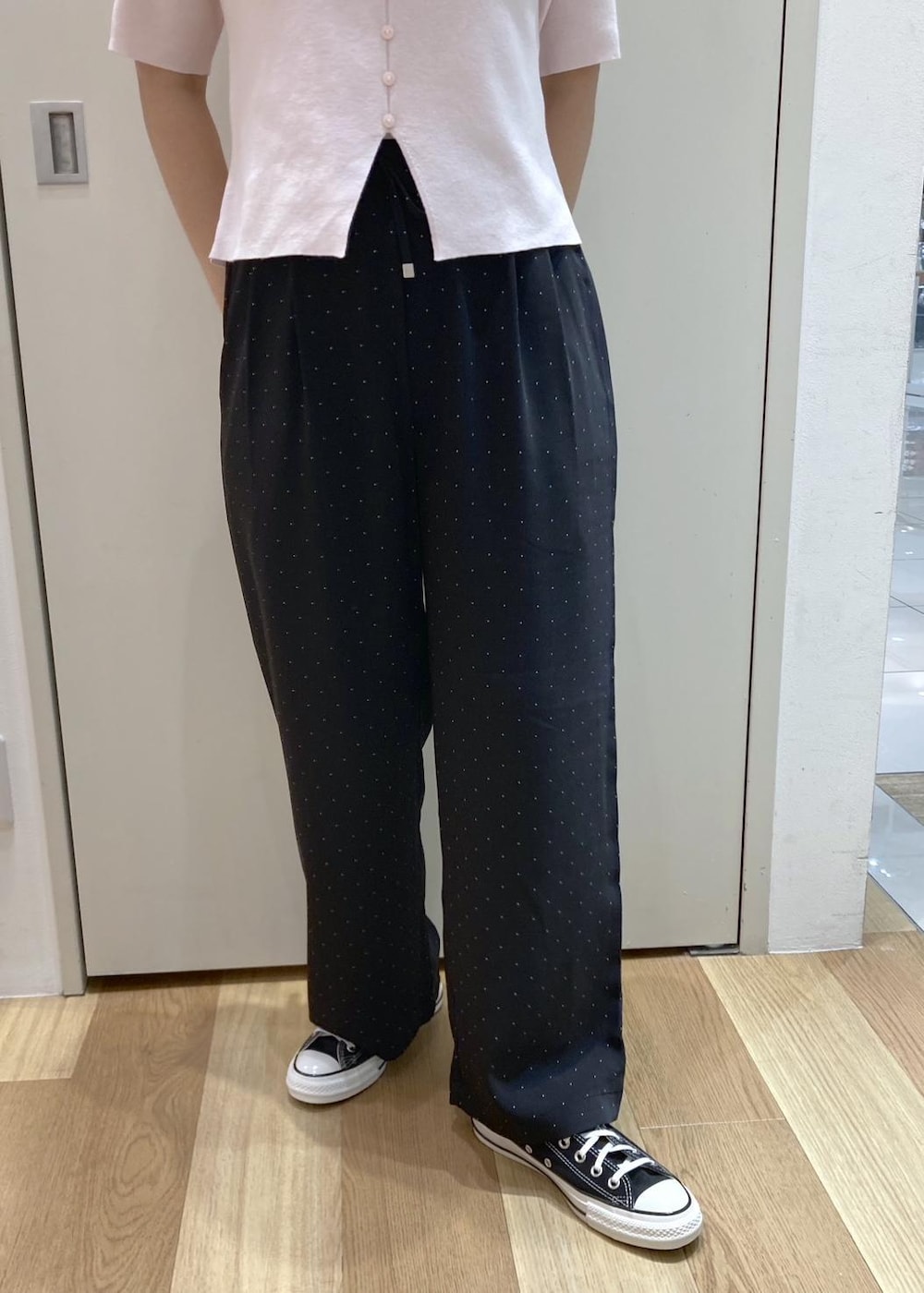 ピンク系のニット/セーター、ブラック系のその他パンツ、ホワイト系のトートバッグを着用したレディースの夏コーディネートの6枚目の写真