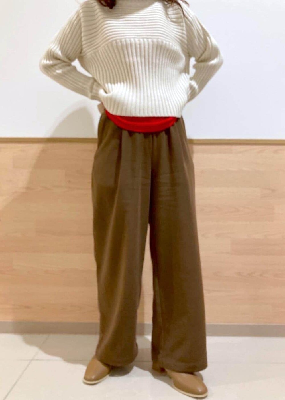 レッド系のTシャツ/カットソー、ホワイト系のニット/セーター、ブラウン系のブーツを着用したレディースの冬コーディネートの5枚目の写真