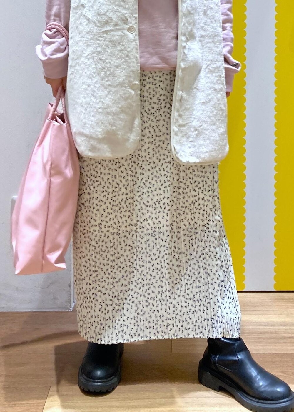 ホワイト系のスカート、ベージュ系のその他アウター、ピンク系のパーカーを着用したレディースの冬コーディネートの3枚目の写真