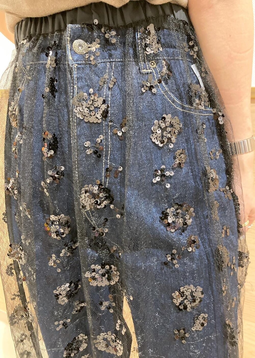 ブルー系のデニムパンツ、ブラック系のサンダル、ブラック系のスカートを着用したレディースの夏コーディネートの7枚目の写真