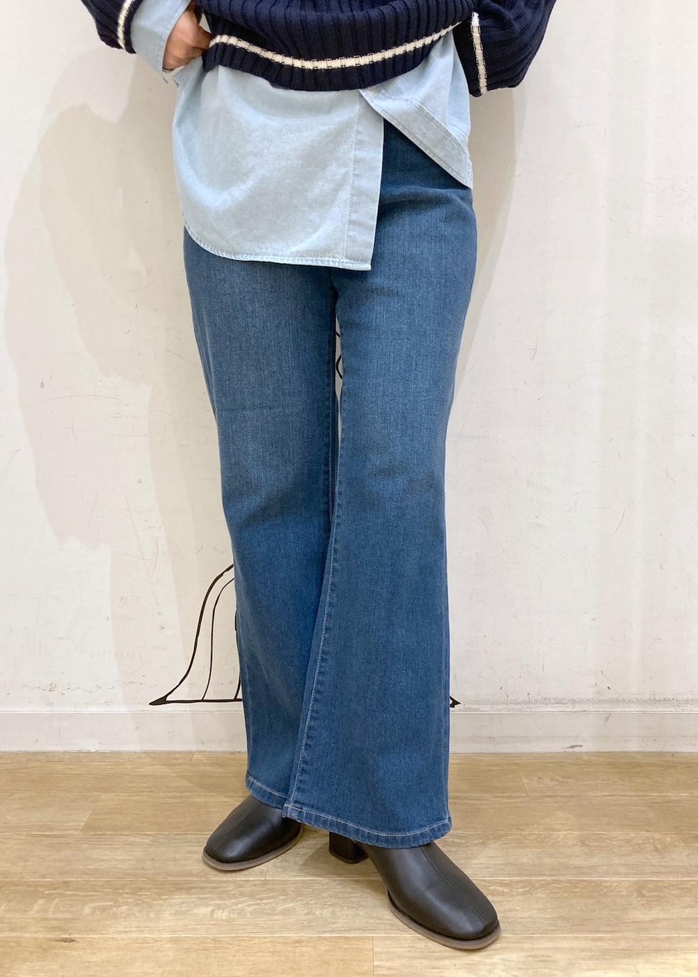 ブルー系のシャツ/ブラウス、ブルー系のニット/セーター、ブラック系のブーツを着用したレディースの秋コーディネートの6枚目の写真