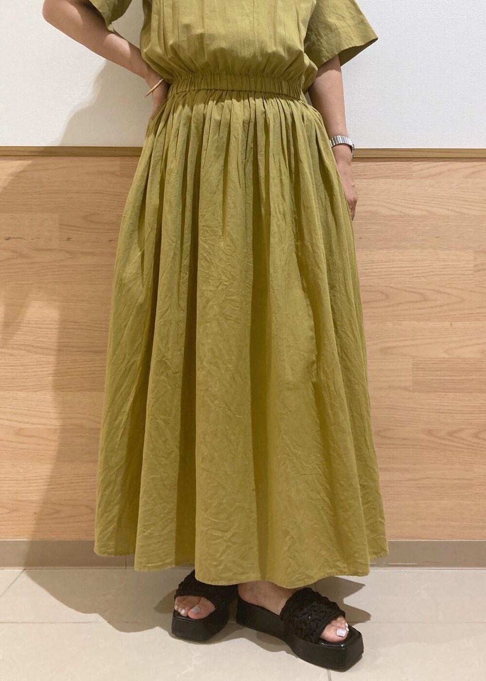 ブラック系のサンダル、ブラック系のかごバッグ、イエロー系のワンピースを着用したレディースの夏コーディネートの6枚目の写真