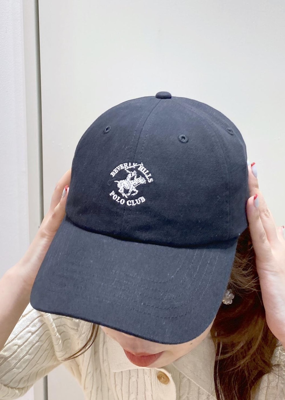 ブラック系のバックパック/リュック、ブラック系のスカート、ホワイト系のニット/セーターを着用したレディースの春コーディネートの6枚目の写真