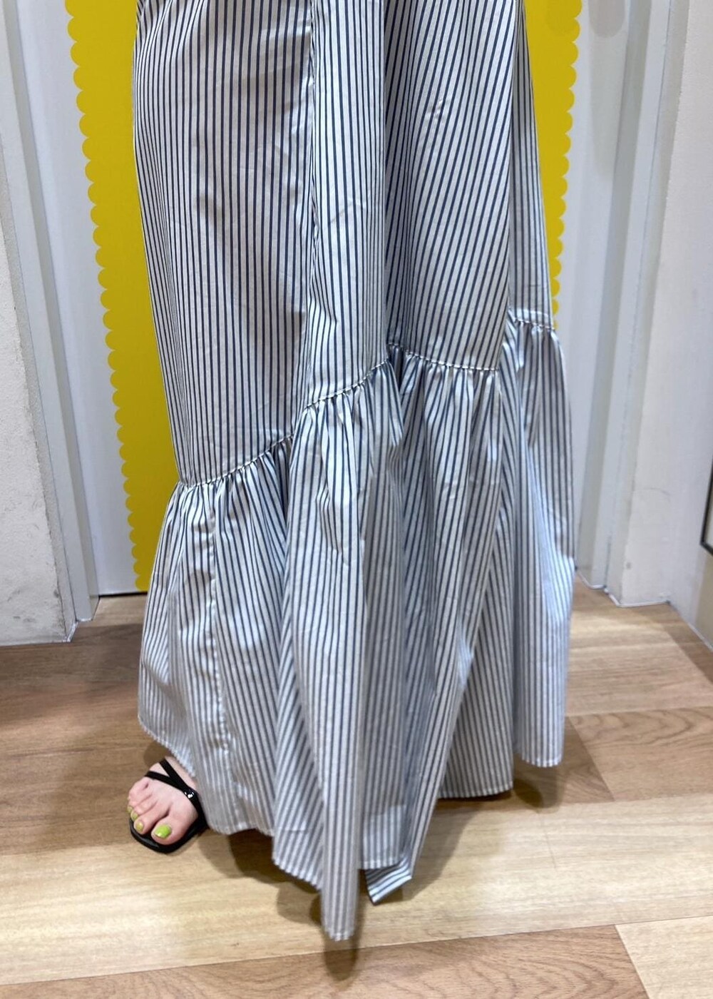 ブラック系のサンダル、ホワイト系のショルダーバッグ、ブルー系のシャツワンピースを着用したレディースの春コーディネートの6枚目の写真