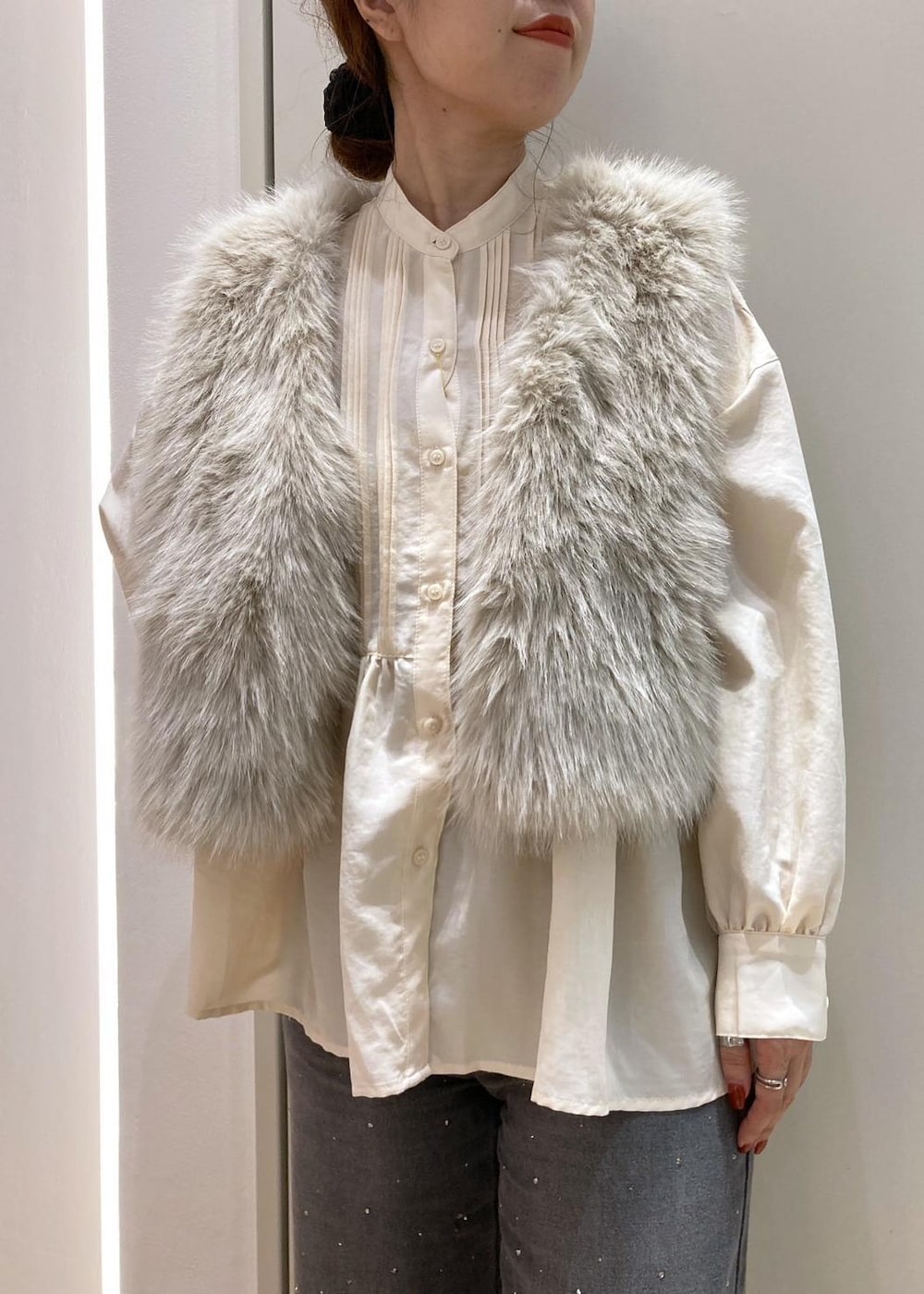 ベージュ系のシャツ/ブラウス、ベージュ系のベスト、ブラック系のデニムパンツを着用したレディースの秋コーディネートの4枚目の写真