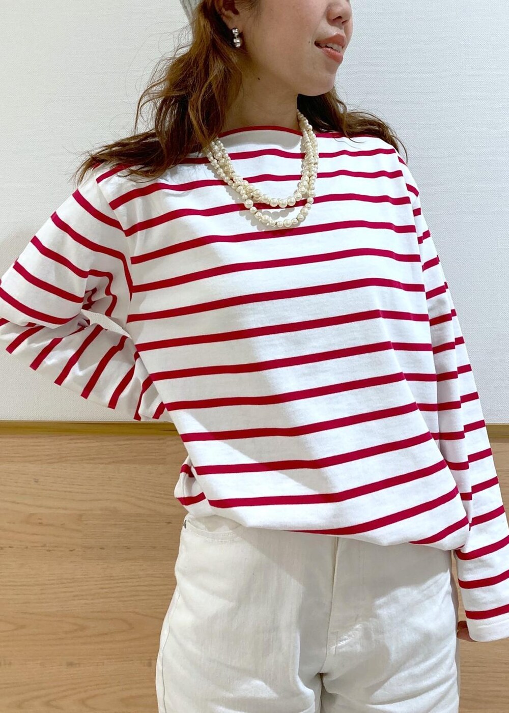 ベージュ系のトレンチコート、レッド系のTシャツ/カットソー、ホワイト系のデニムパンツを着用したレディースの春コーディネートの3枚目の写真