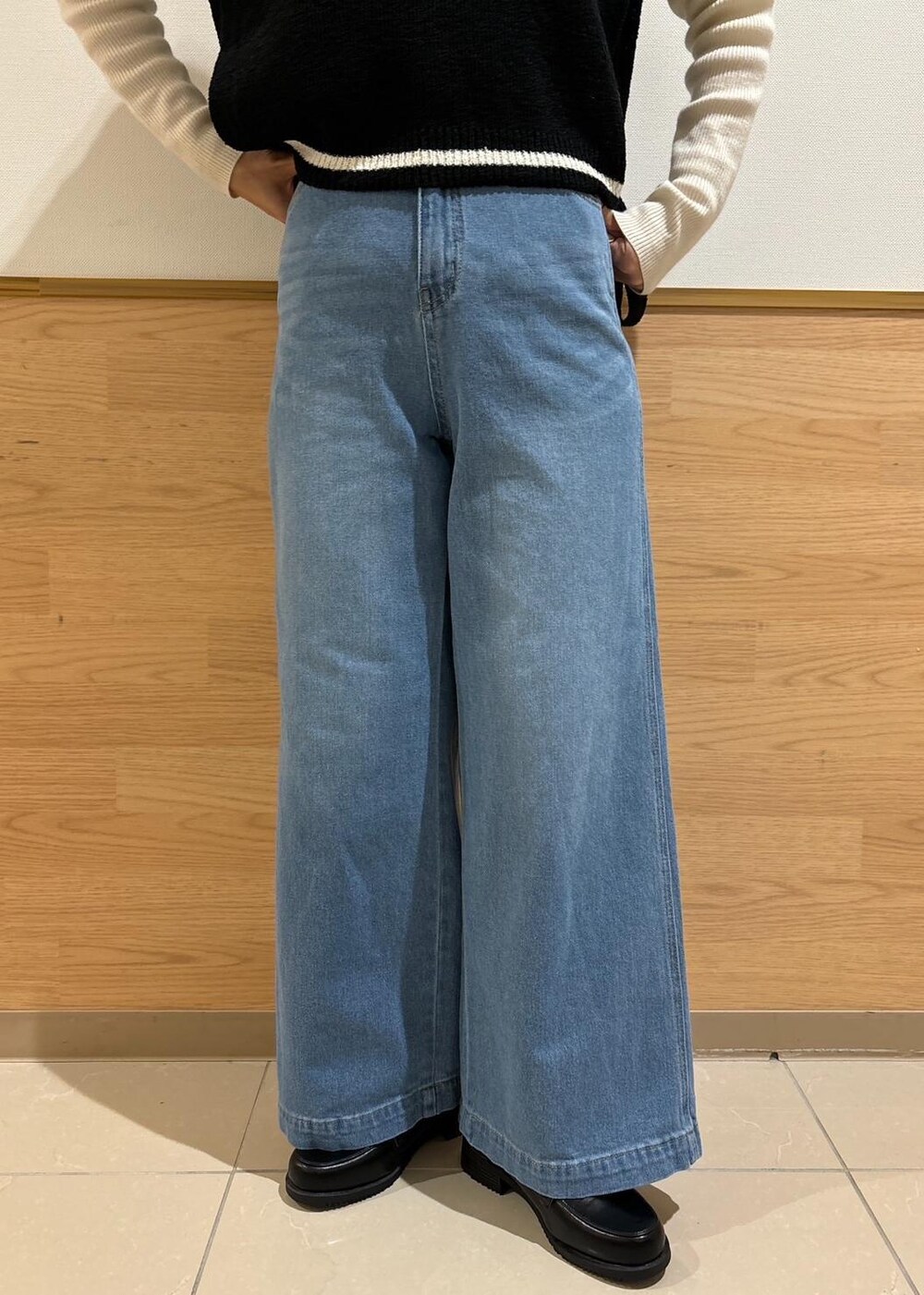 ホワイト系のニット/セーター、ブラック系のローファー、ブラック系のベストを着用したレディースの冬コーディネートの4枚目の写真