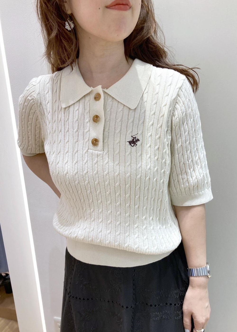 ブラック系のバックパック/リュック、ブラック系のスカート、ホワイト系のニット/セーターを着用したレディースの春コーディネートの4枚目の写真