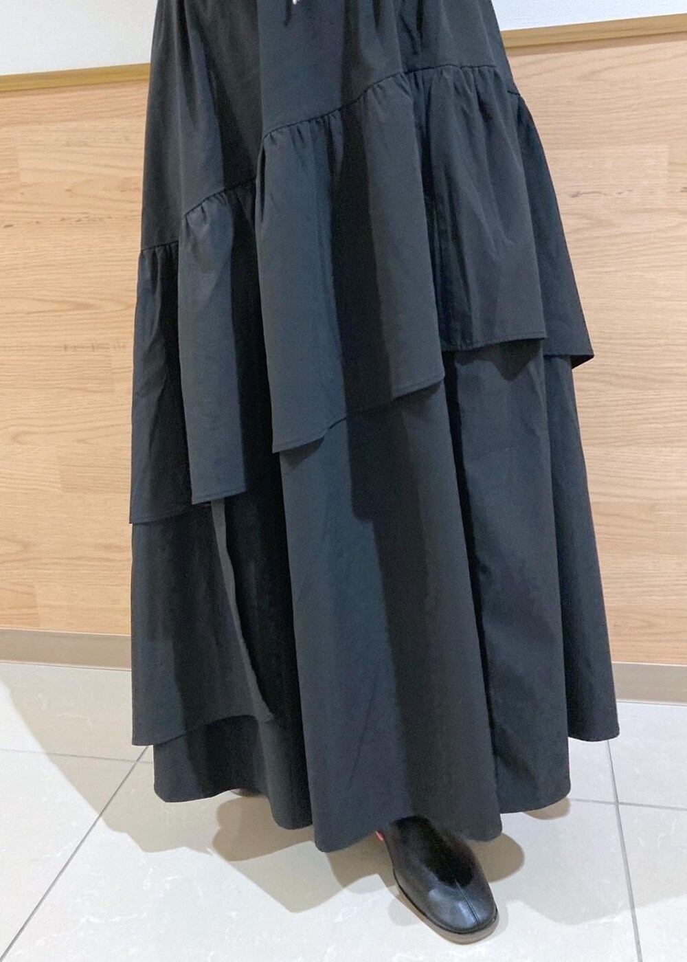 ブラウン系のダウンジャケット/コート、グレー系のニット/セーター、ブラック系のブーツを着用したレディースの冬コーディネートの7枚目の写真