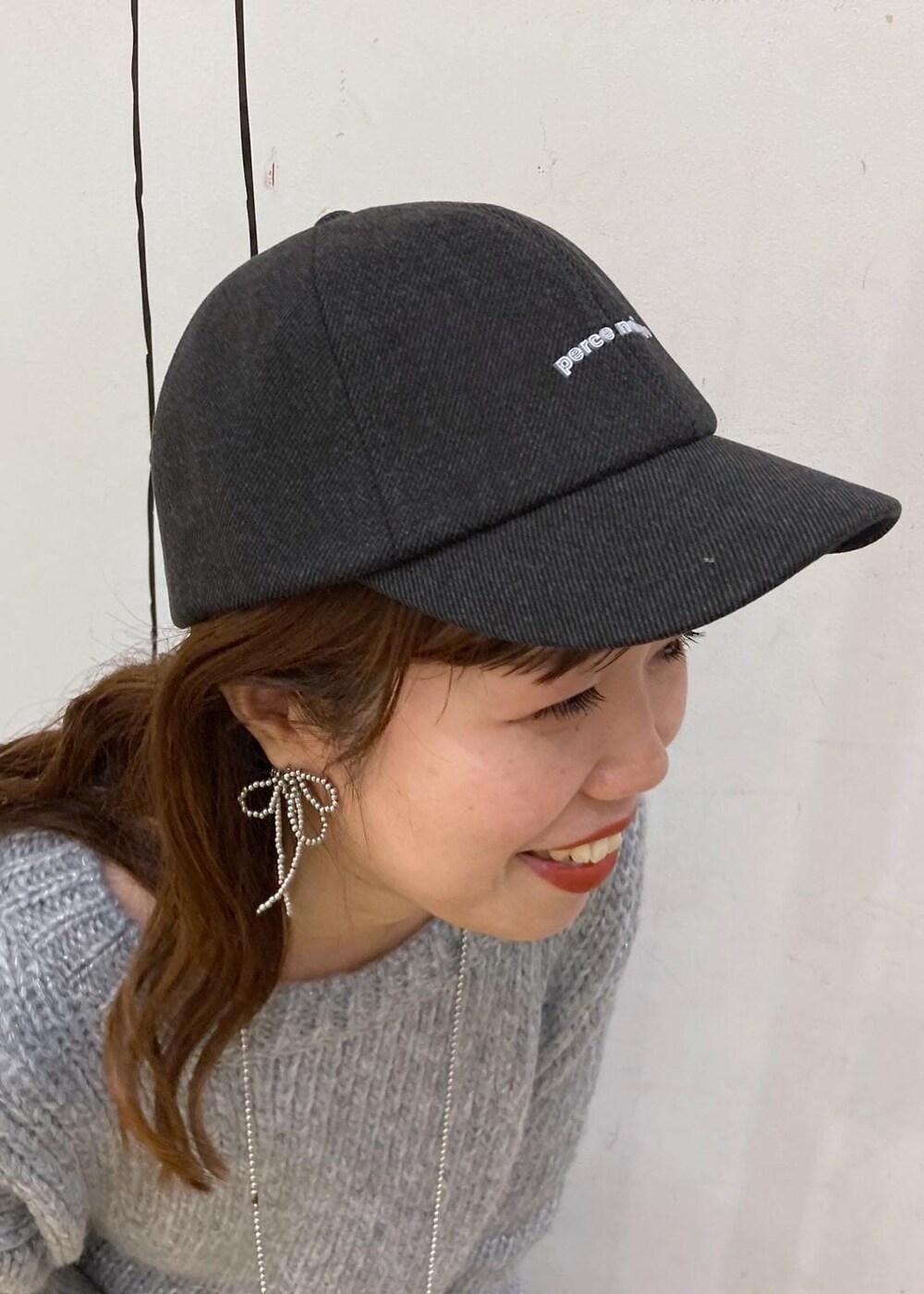 ホワイト系のTシャツ/カットソー、グレー系のニット/セーター、レッド系のトートバッグを着用したレディースの冬コーディネートの9枚目の写真