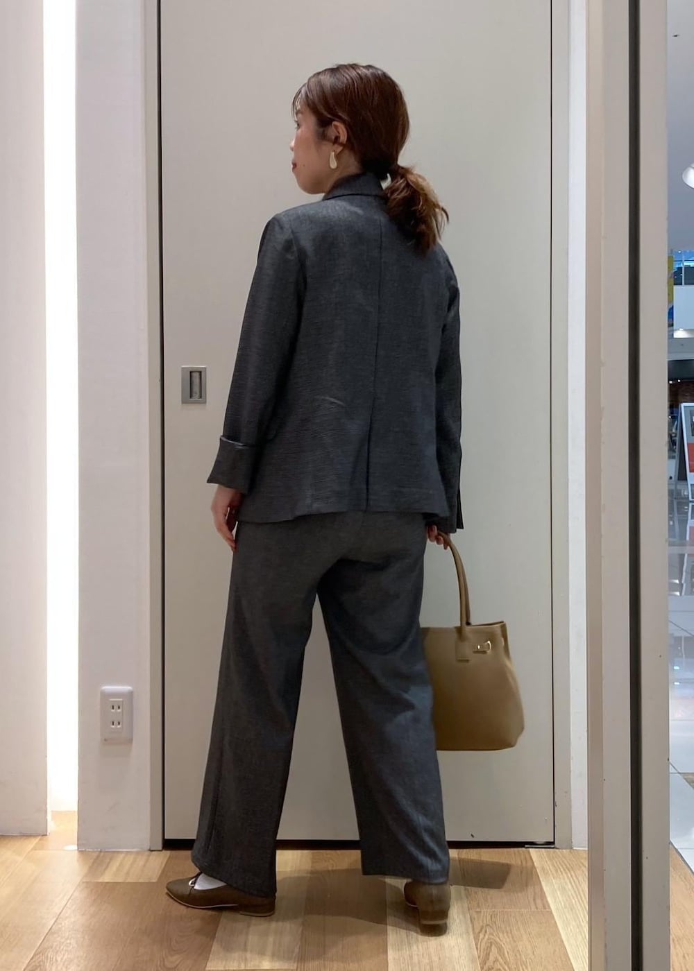 イエロー系のトートバッグ、パープル系のタンクトップ、グレー系のテーラードジャケットを着用したレディースの秋コーディネートの3枚目の写真