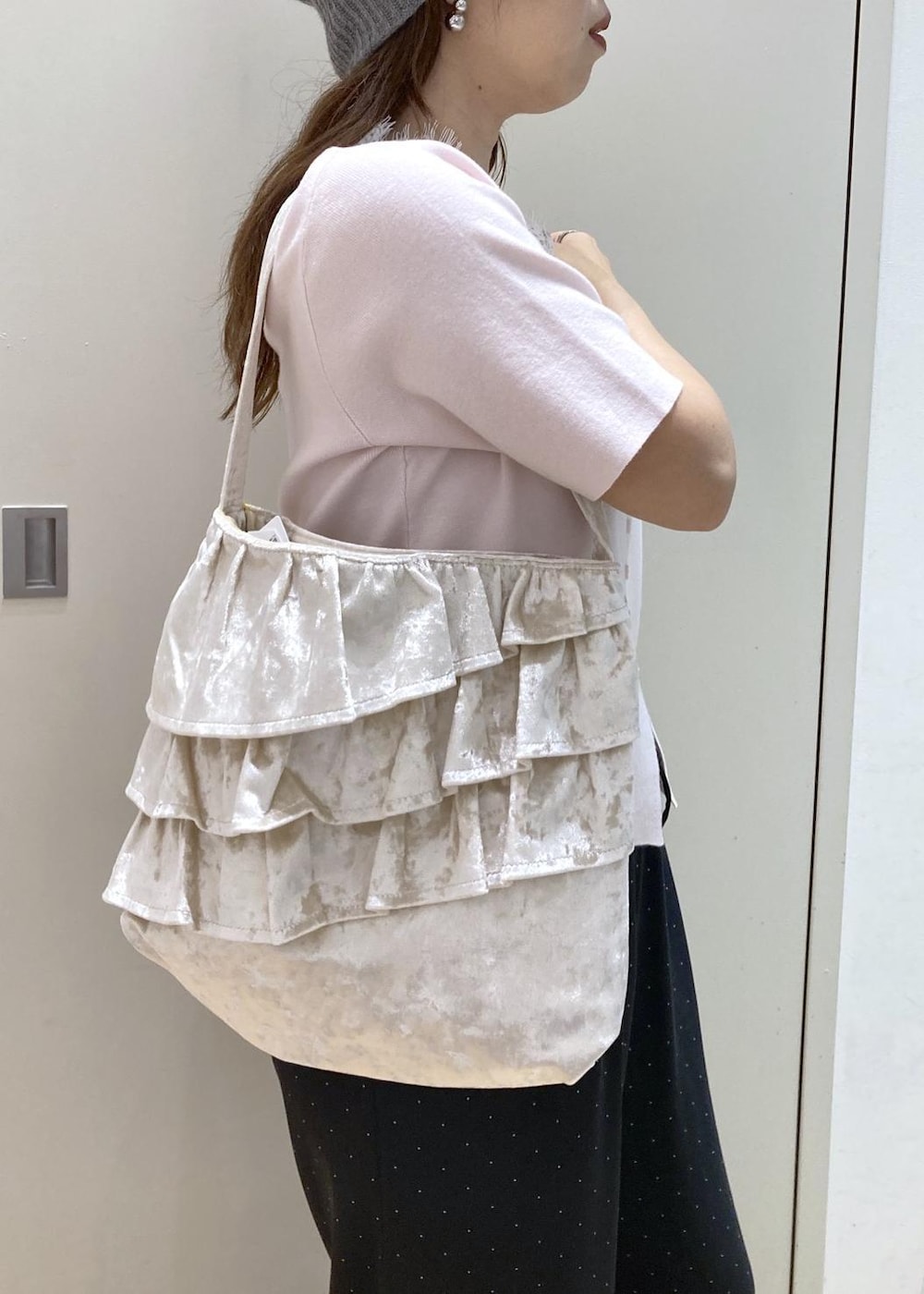 ピンク系のニット/セーター、ブラック系のその他パンツ、ホワイト系のトートバッグを着用したレディースの夏コーディネートの8枚目の写真