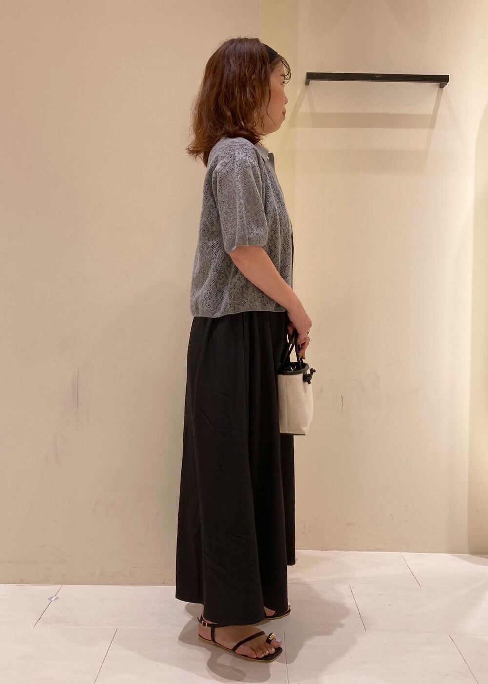 ブラック系のサンダル、ブラック系のワンピース、グレー系のカーディガン/ボレロを着用したレディースの夏コーディネートの2枚目の写真