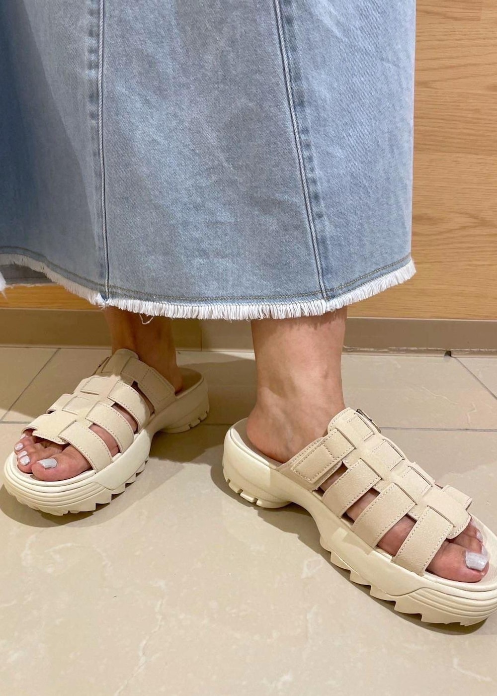 ホワイト系のサンダル、ブルー系のデニムスカート、ホワイト系のTシャツ/カットソーを着用したレディースの夏コーディネートの7枚目の写真