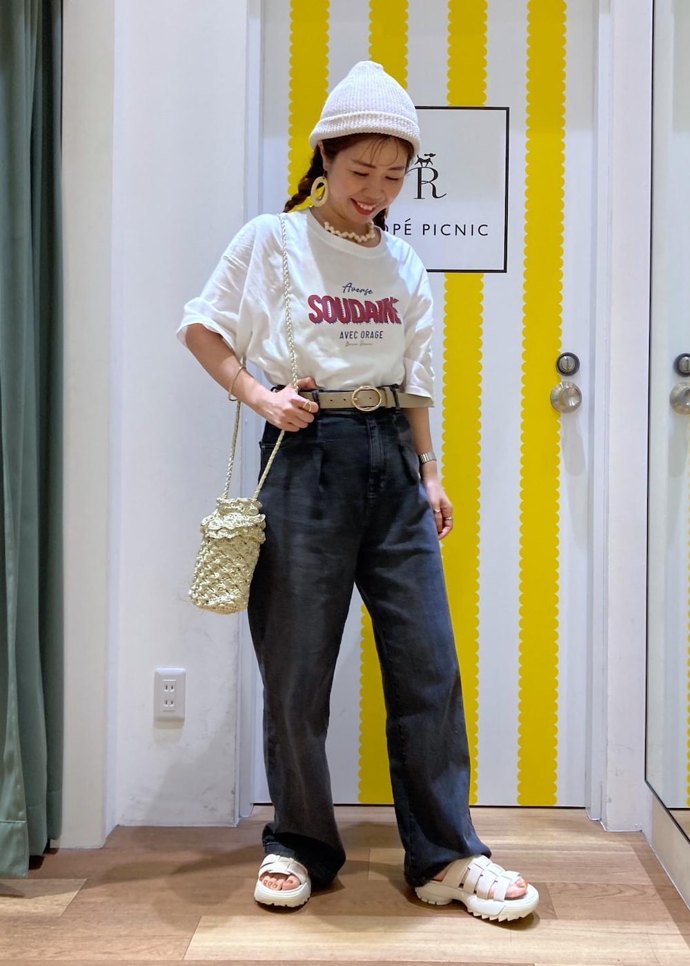 ホワイト系のサンダル、ゴールド系のショルダーバッグ、ブラック系のデニムパンツを着用したレディースの夏コーディネートの3枚目の写真