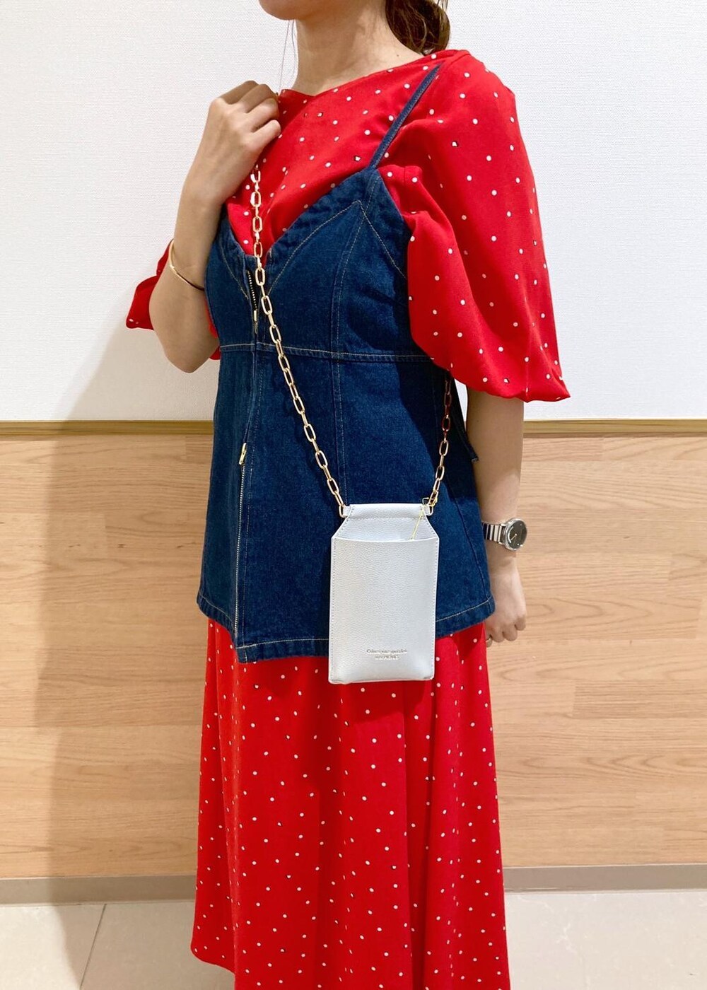 ブラック系のサンダル、シルバー系のショルダーバッグ、ブルー系のベストを着用したレディースの春コーディネートの7枚目の写真