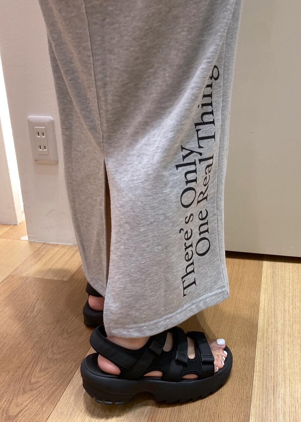 ブラック系のサンダル、レッド系のトートバッグ、グレー系のスカートを着用したレディースの夏コーディネートの6枚目の写真