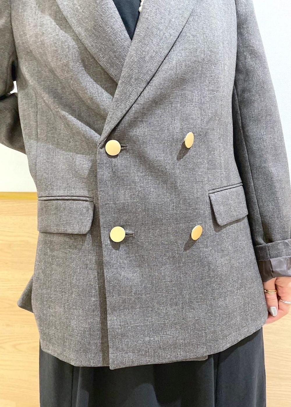 ブラウン系のテーラードジャケット、ブラック系のハンドバッグ、ブラック系のワンピースを着用したレディースの秋コーディネートの6枚目の写真