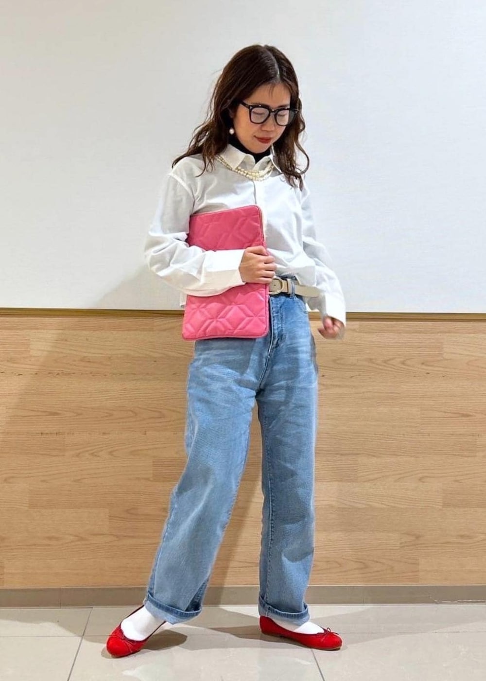 ブラック系のニット/セーター、ブルー系のデニムパンツ、ホワイト系のシャツ/ブラウスを着用したレディースの冬コーディネートの2枚目の写真