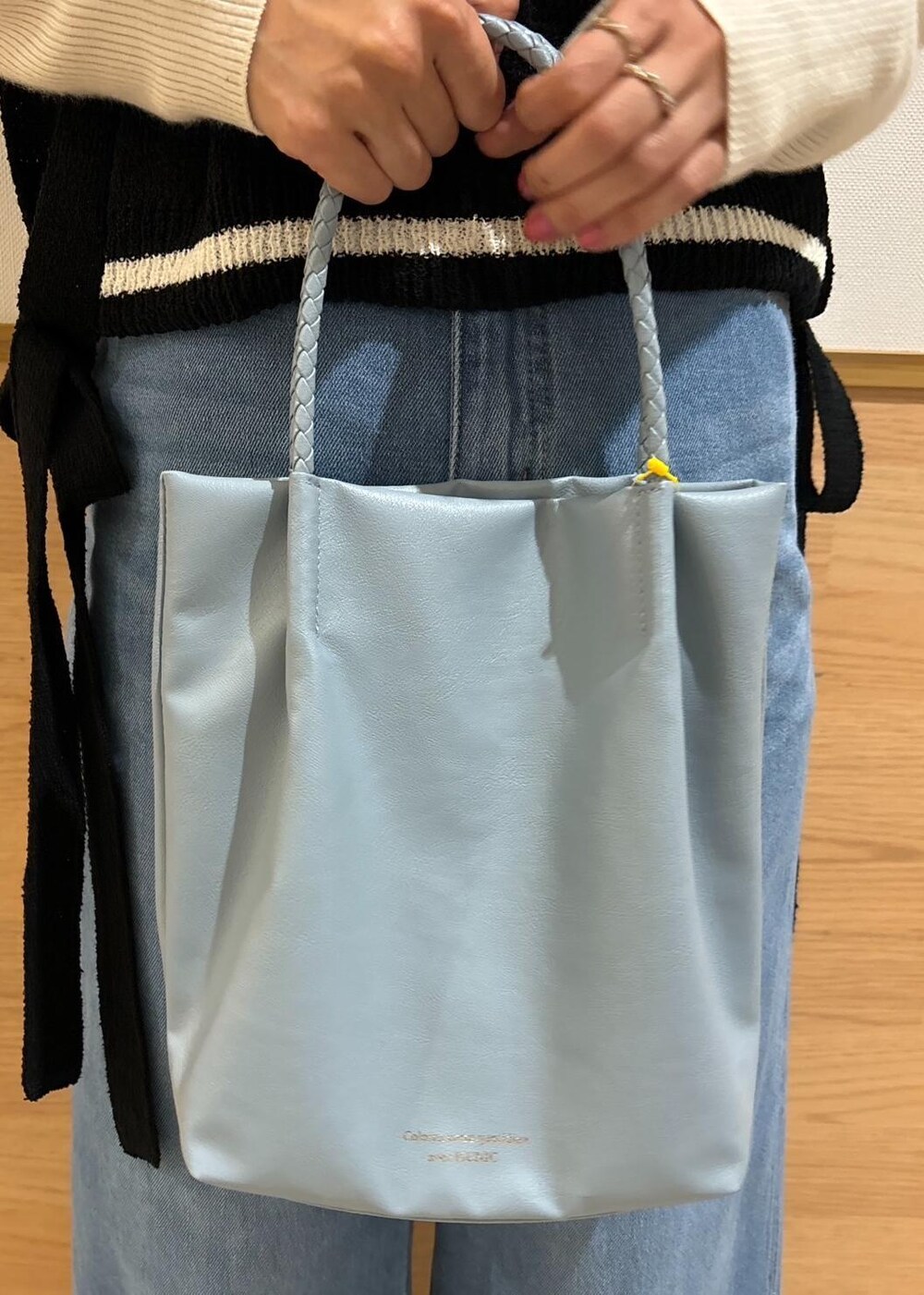 ホワイト系のニット/セーター、ブラック系のローファー、ブラック系のベストを着用したレディースの冬コーディネートの6枚目の写真