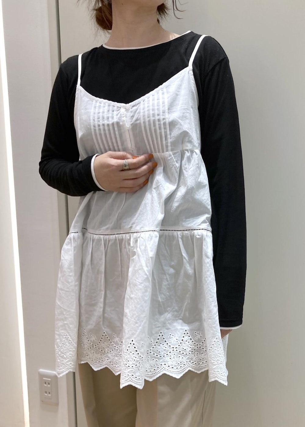 ホワイト系のキャミソール、ベージュ系のチノパンツ、ブラウン系のボストンバッグを着用したレディースの冬コーディネートの4枚目の写真