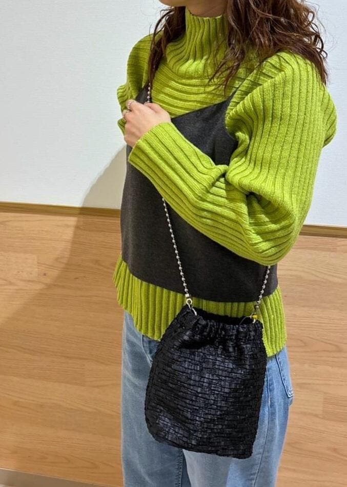 グリーン系のニット/セーター、グレー系のニット/セーター、ブラック系のショルダーバッグを着用したレディースの冬コーディネートの4枚目の写真