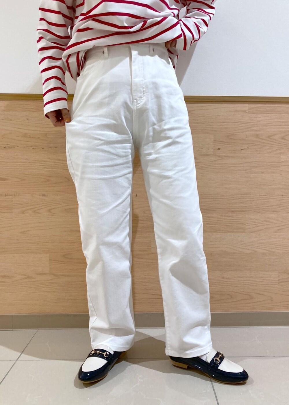 ベージュ系のトレンチコート、レッド系のTシャツ/カットソー、ホワイト系のデニムパンツを着用したレディースの春コーディネートの4枚目の写真