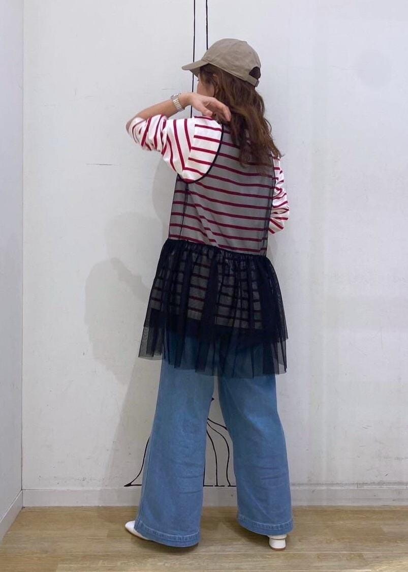 ブラック系のベスト、レッド系のTシャツ/カットソー、ホワイト系のパンプスを着用したレディースの春コーディネートの3枚目の写真