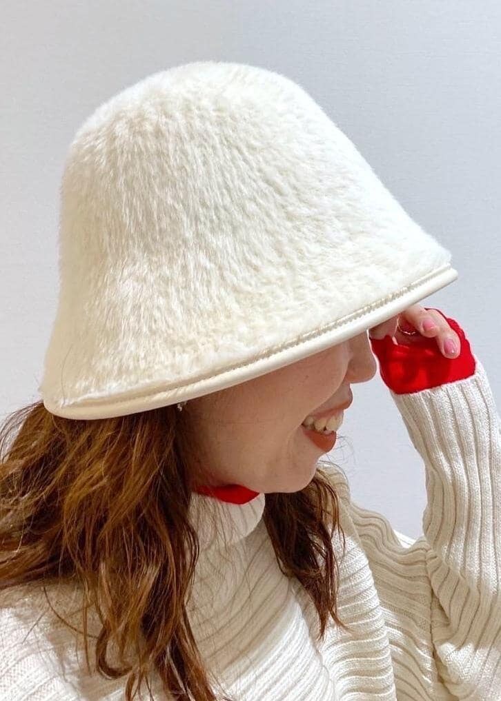 レッド系のTシャツ/カットソー、ホワイト系のニット/セーター、ブラウン系のブーツを着用したレディースの冬コーディネートの4枚目の写真