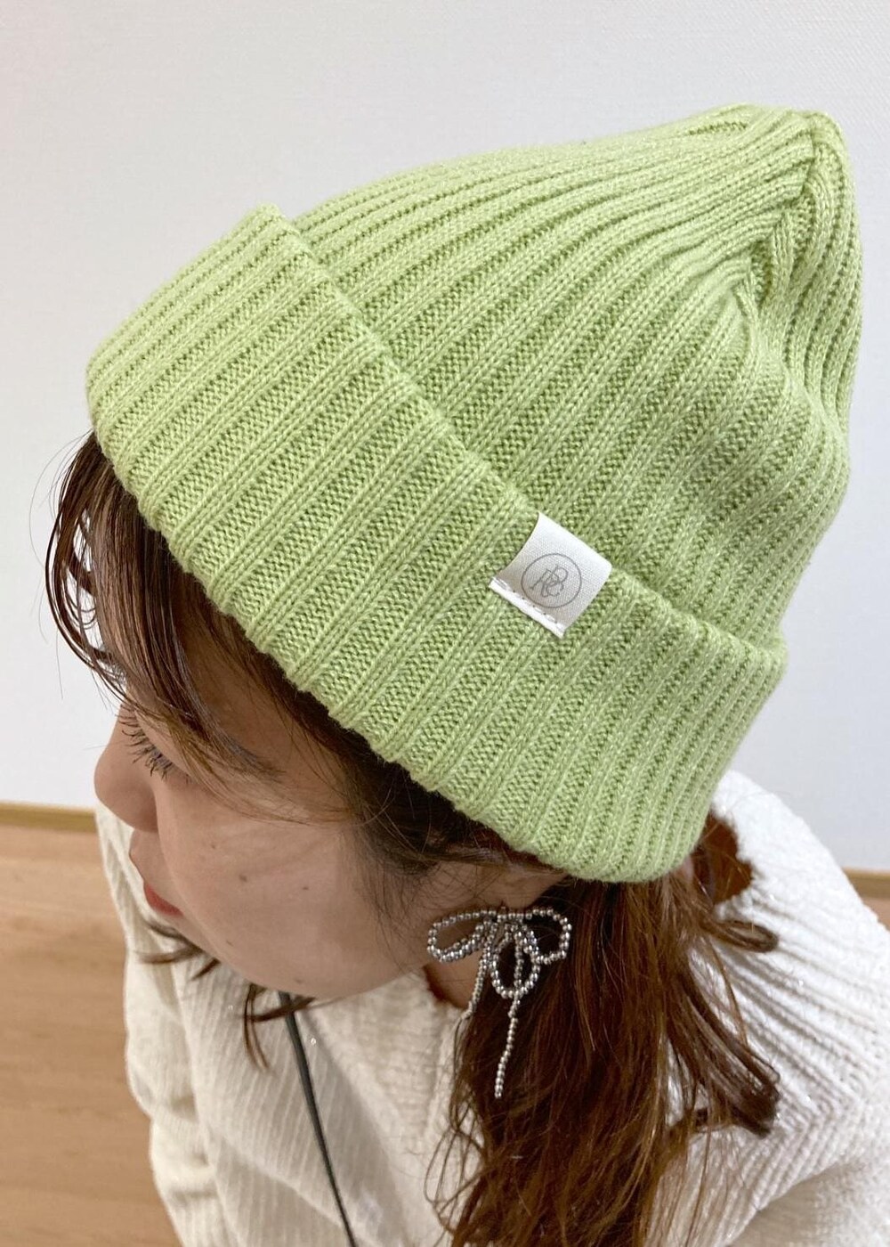 ホワイト系のニット/セーター、ブラック系のバレエシューズ、ベージュ系のチノパンツを着用したレディースの冬コーディネートの9枚目の写真