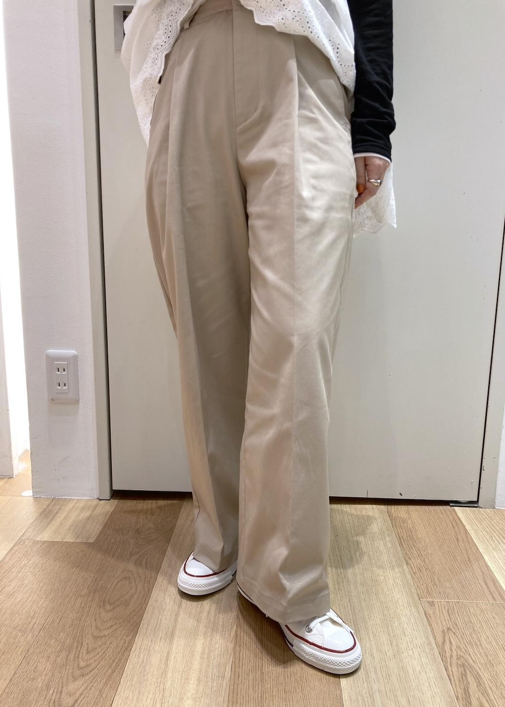 ホワイト系のキャミソール、ベージュ系のチノパンツ、ブラウン系のボストンバッグを着用したレディースの冬コーディネートの5枚目の写真