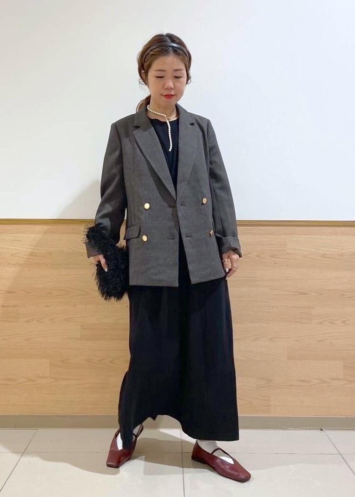 ブラウン系のテーラードジャケット、ブラック系のハンドバッグ、ブラック系のワンピースを着用したレディースの秋コーディネートの2枚目の写真