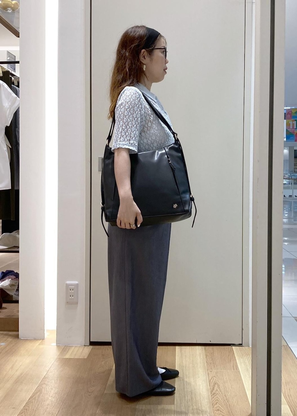 ブラック系のバレエシューズ、ブルー系のシャツ/ブラウス、ブラック系のショルダーバッグを着用したレディースの春コーディネートの2枚目の写真
