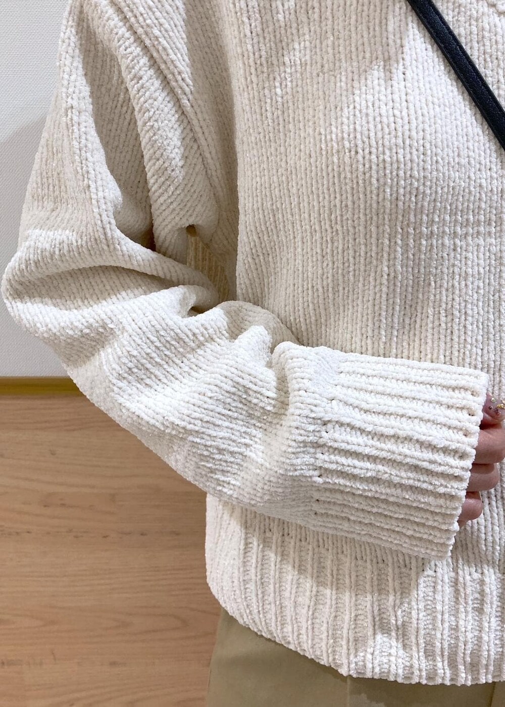 ホワイト系のニット/セーター、ブラック系のバレエシューズ、ベージュ系のチノパンツを着用したレディースの冬コーディネートの5枚目の写真