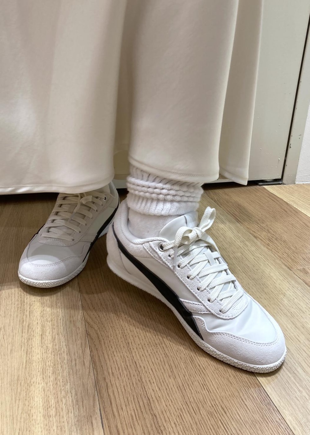 グレー系のニット/セーター、ホワイト系のスニーカー、ブラック系のショルダーバッグを着用したレディースの冬コーディネートの7枚目の写真