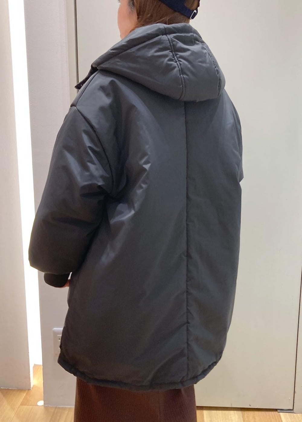 ホワイト系のTシャツ/カットソー、ブラック系のダウンジャケット/コート、ブラック系のローファーを着用したレディースの秋コーディネートの9枚目の写真