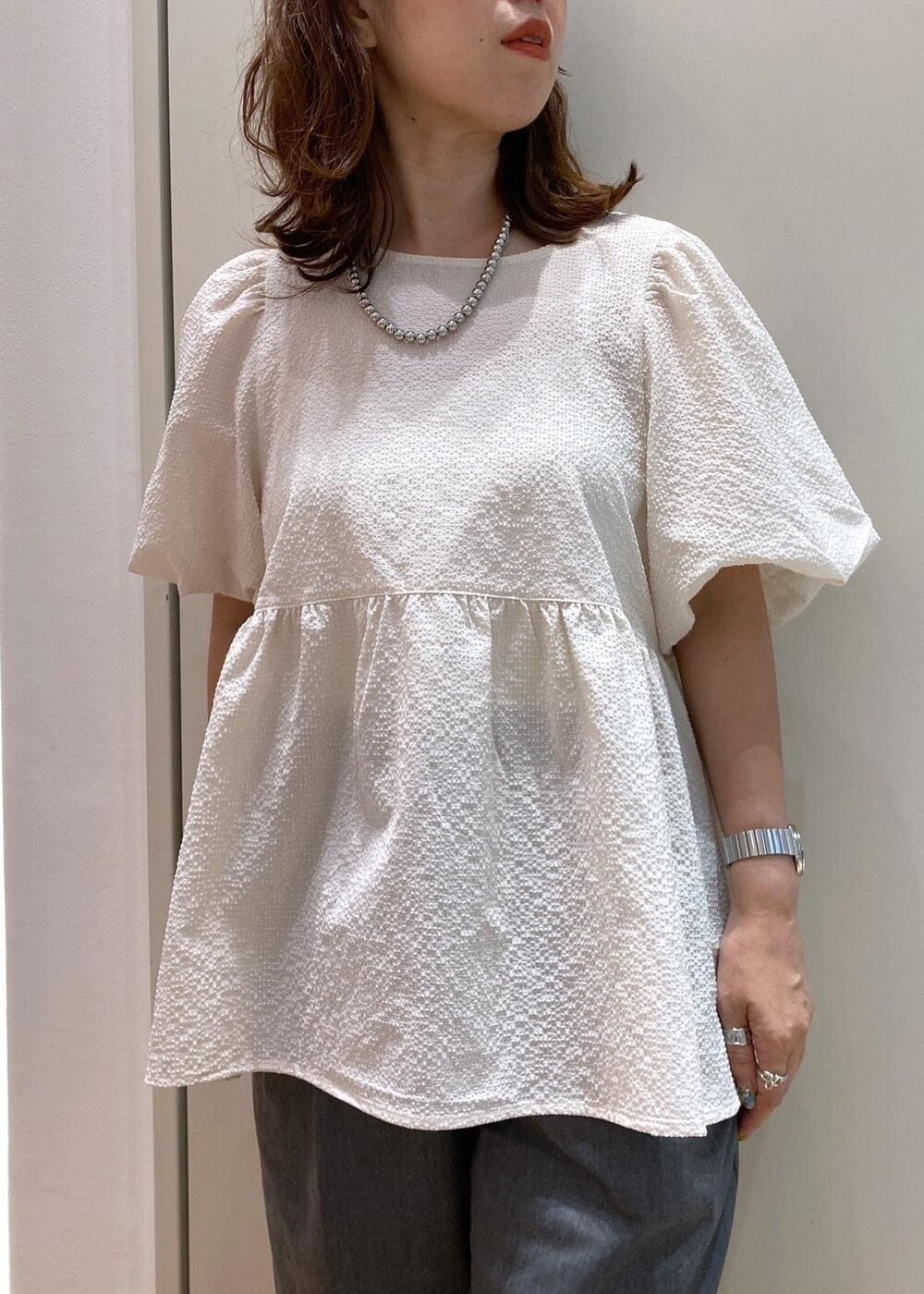 ブラック系のバレエシューズ、グレー系のチノパンツ、ホワイト系のシャツ/ブラウスを着用したレディースの夏コーディネートの5枚目の写真